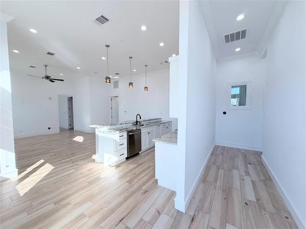 a view of a kitchen with kitchen island wooden floors granite counter tops and a stove