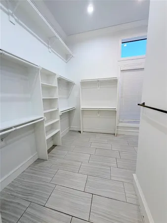 a view of walk in closet with empty racks
