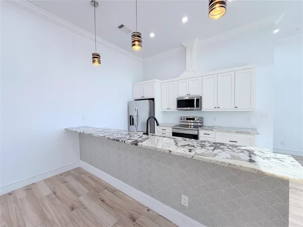 a kitchen with stainless steel appliances a stove a sink a microwave and wooden cabinets