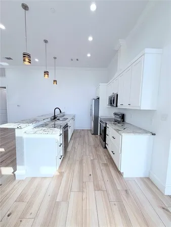 a kitchen with stove cabinets and wooden floor