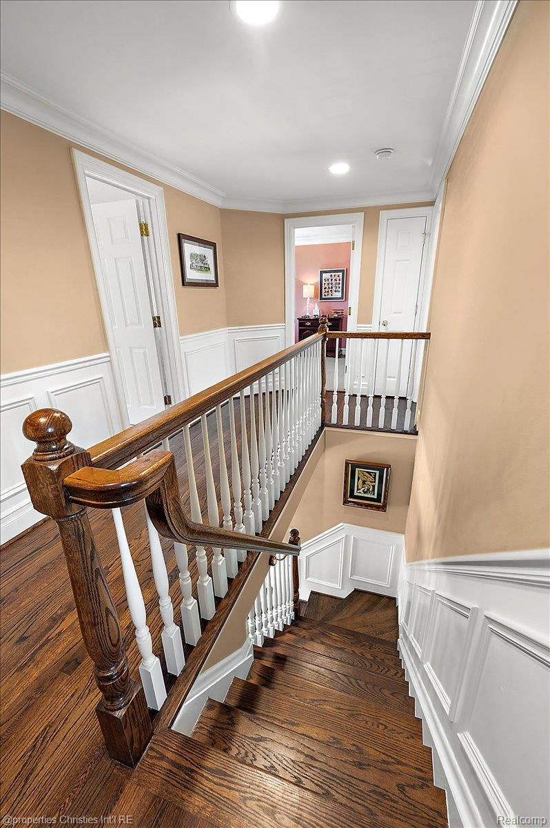 135 Clifton Road Bloomfield Hills, MI 48301 - Photo 44 of 77 Hardwood staircase with white balusters and a dark wood handrail
