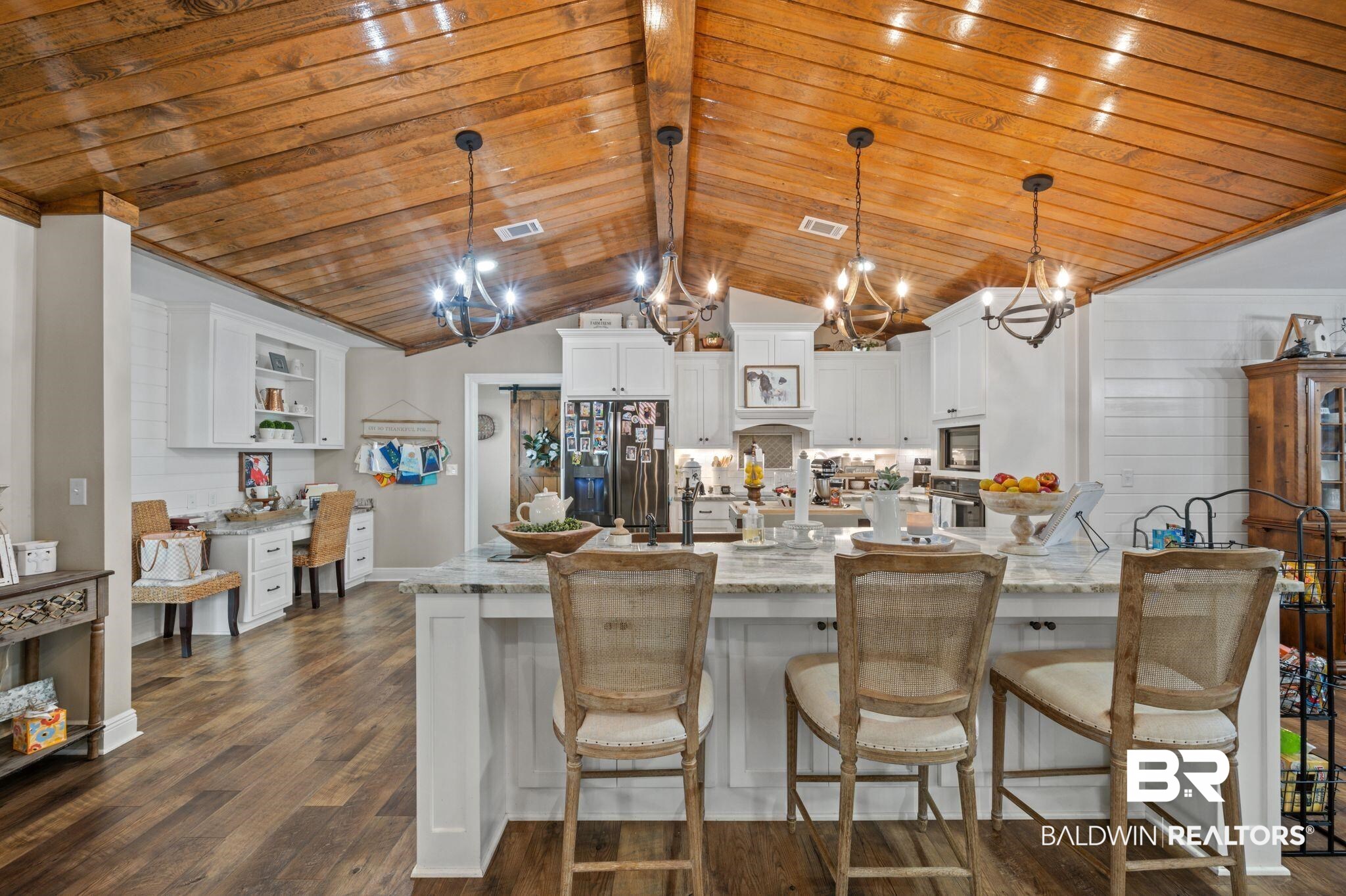 38211-d) V R Byrd Road Bay Minette, AL 36507 - Photo 10 of 58 Kitchen with hanging light fixtures, dark hardwood / wood-style floors, white cabinets, wood ceiling, and appliances with stainless steel finishes