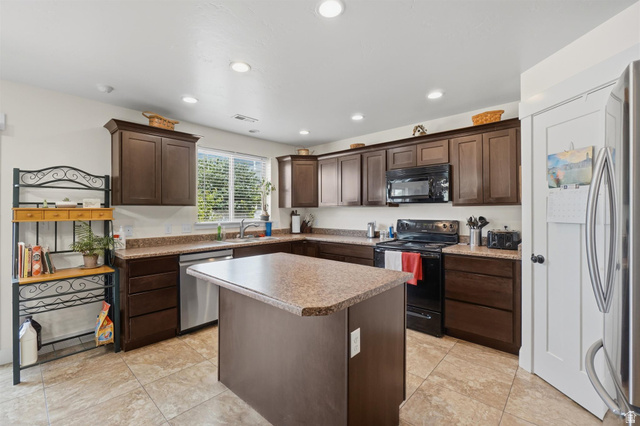 592 West 650 South Springville, UT 84663 - Photo 11 of 33 Kitchen featuring a central island, recessed lighting, wood-finish cabinetry, tile flooring, and a window with blinds
