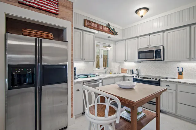 a kitchen with a stove a refrigerator and a microwave