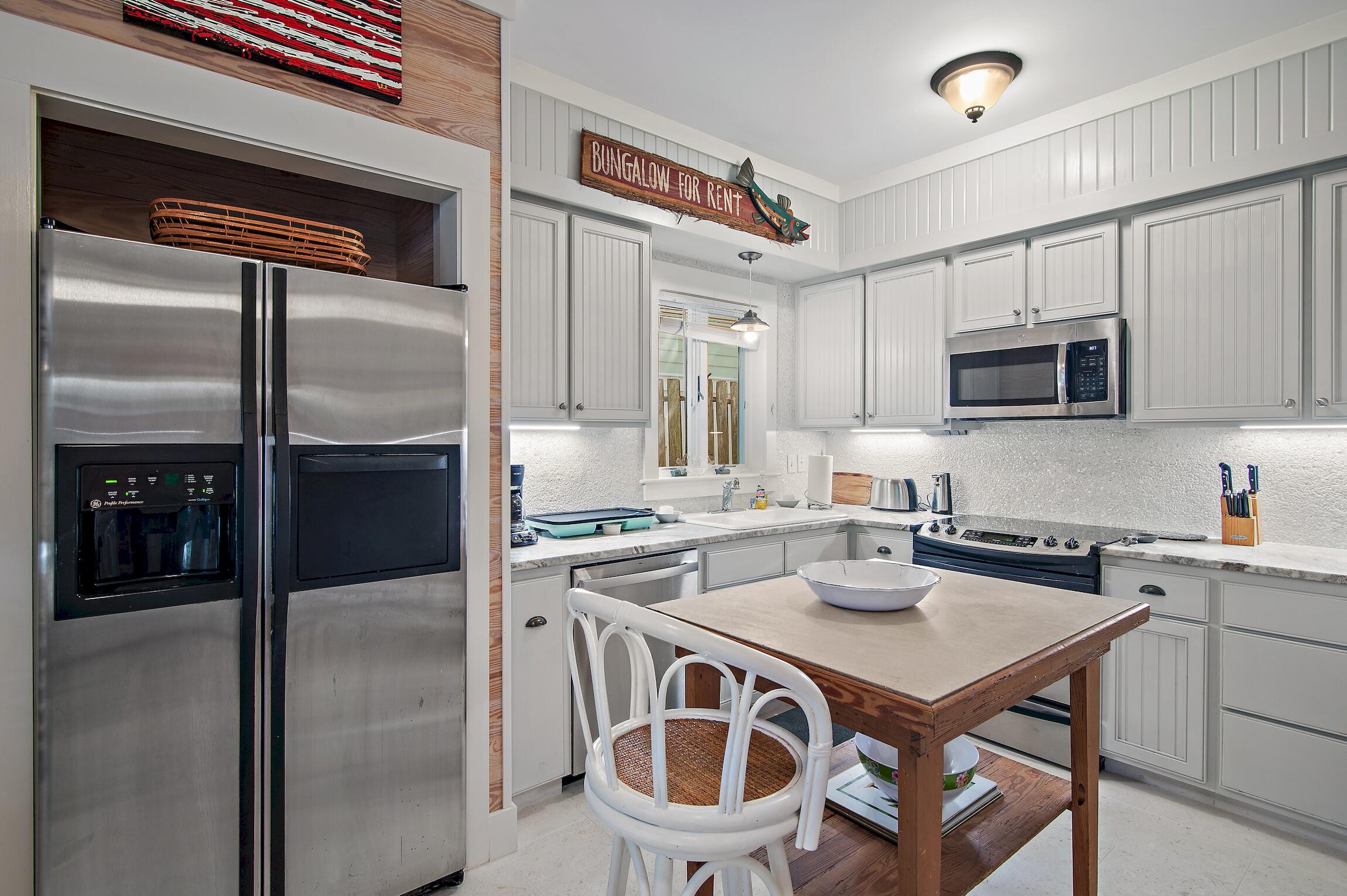 291 South Gulf Drive Santa Rosa Beach, FL 32459 - Photo 8 of 23 a kitchen with a stove a refrigerator and a microwave