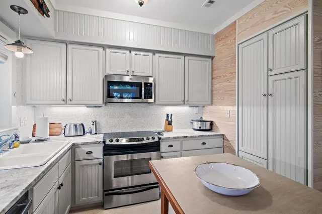 a kitchen with stainless steel appliances a stove a sink and cabinets