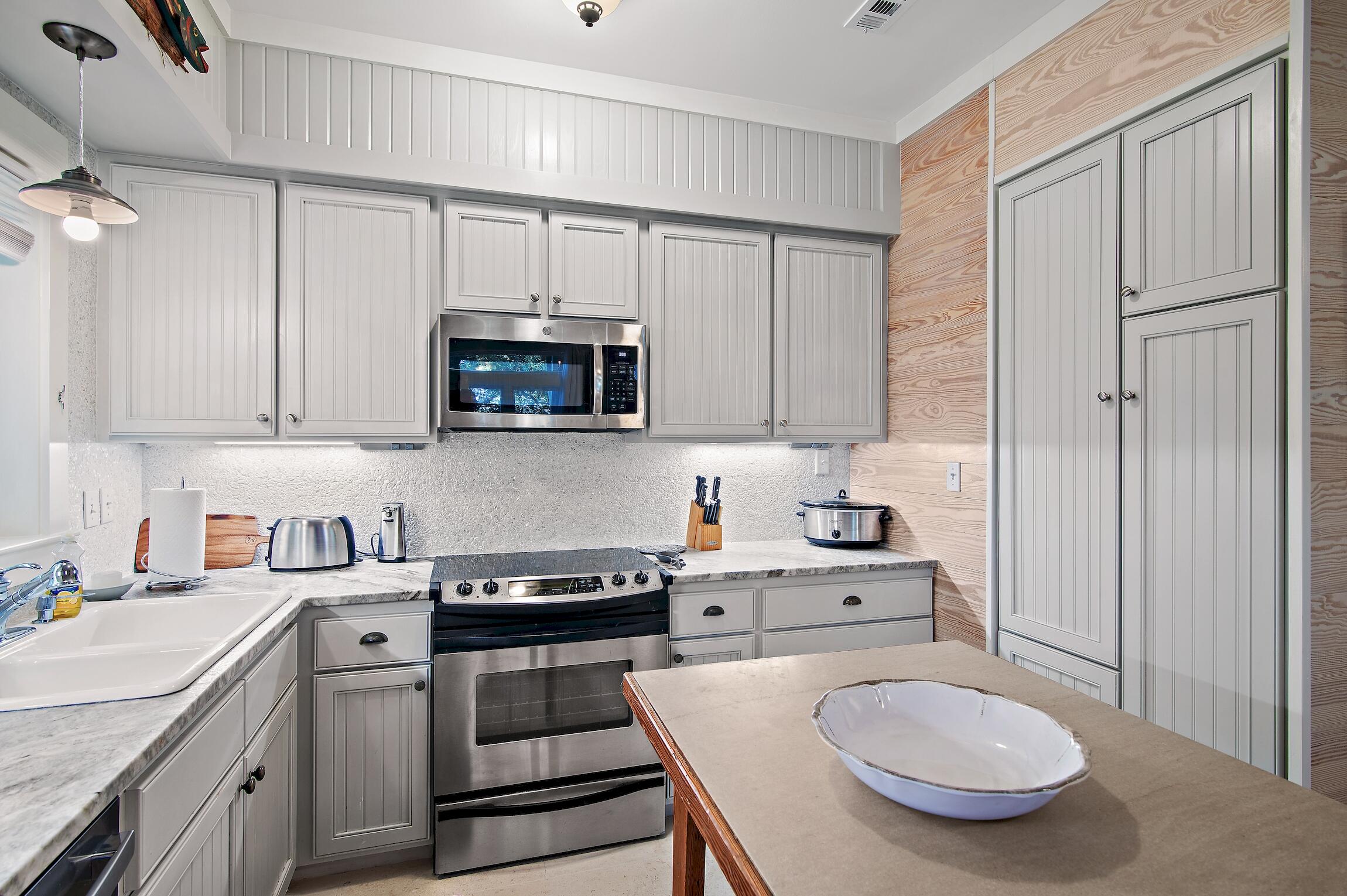 291 South Gulf Drive Santa Rosa Beach, FL 32459 - Photo 9 of 23 a kitchen with stainless steel appliances a stove a sink and cabinets