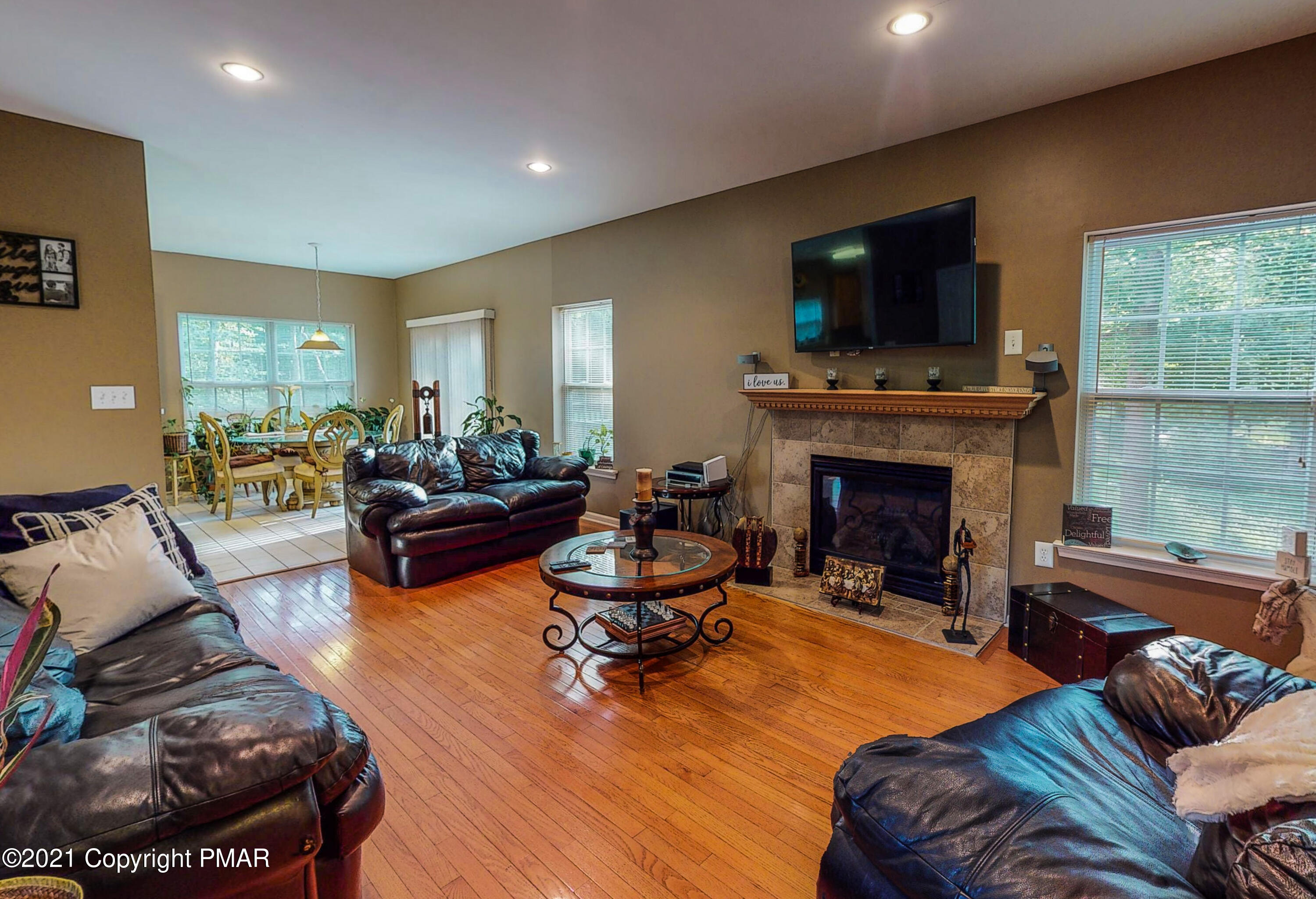 5631 Decker Road Bushkill, PA 18324 - Photo 11 of 61 a living room with furniture a flat screen tv and a fireplace