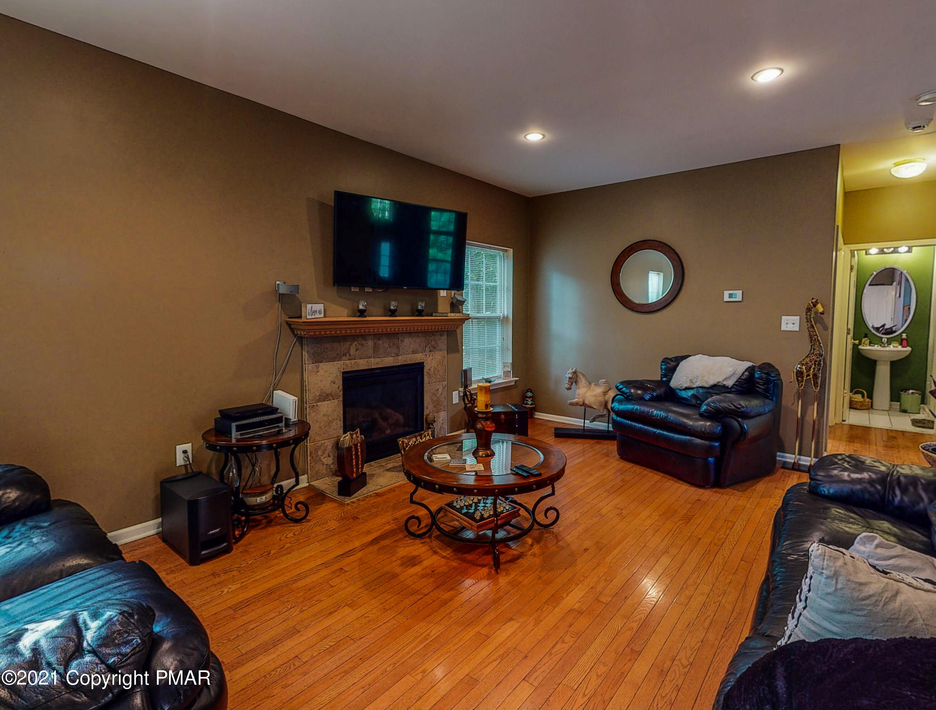 5631 Decker Road Bushkill, PA 18324 - Photo 12 of 61 a living room with furniture a flat screen tv and a fireplace