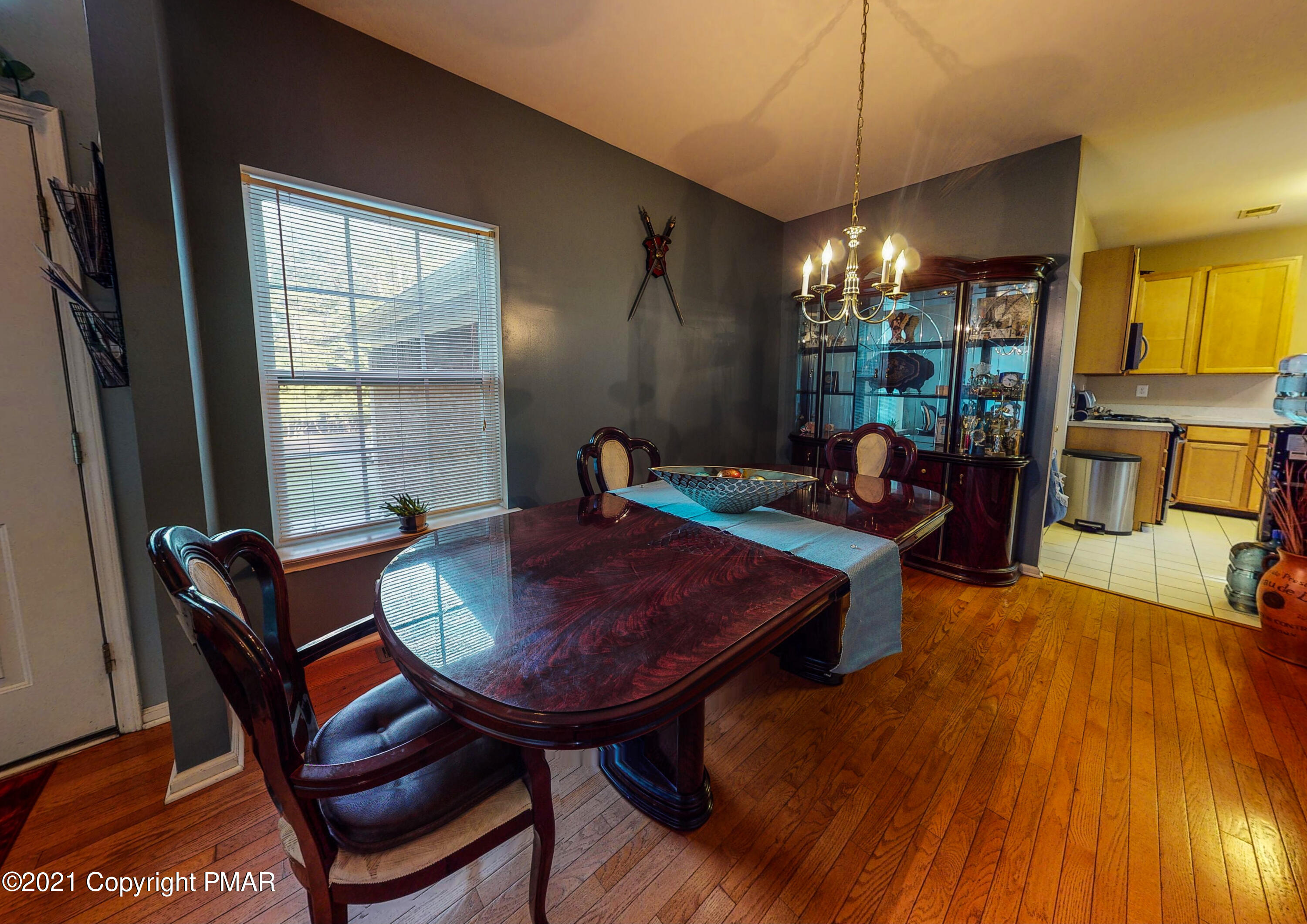 5631 Decker Road Bushkill, PA 18324 - Photo 16 of 61 a dining room with furniture a chandelier and wooden floor