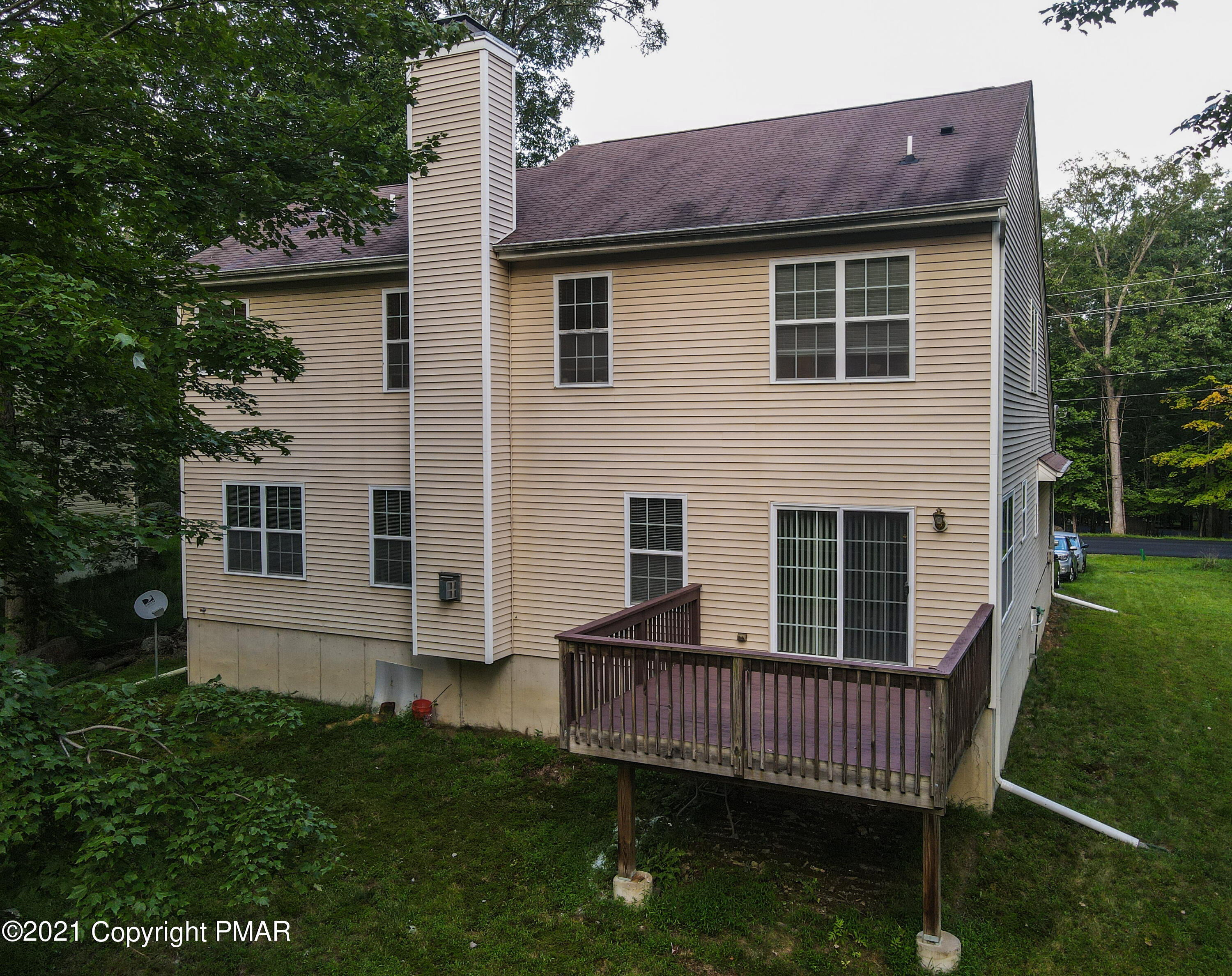 5631 Decker Road Bushkill, PA 18324 - Photo 50 of 61 a view of a house with a small yard and a wooden deck
