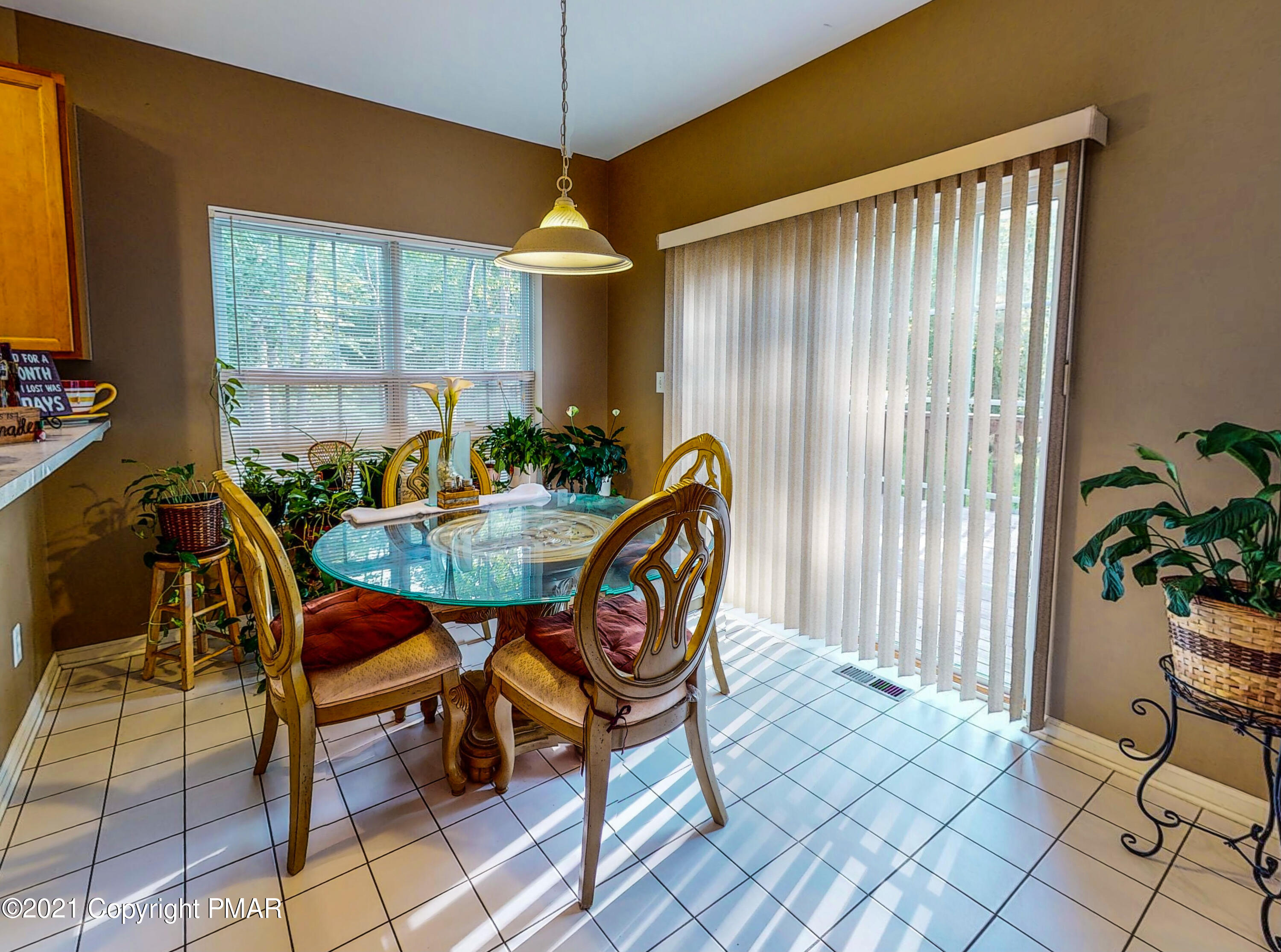 5631 Decker Road Bushkill, PA 18324 - Photo 10 of 61 a dining room with furniture potted plants and wooden floor