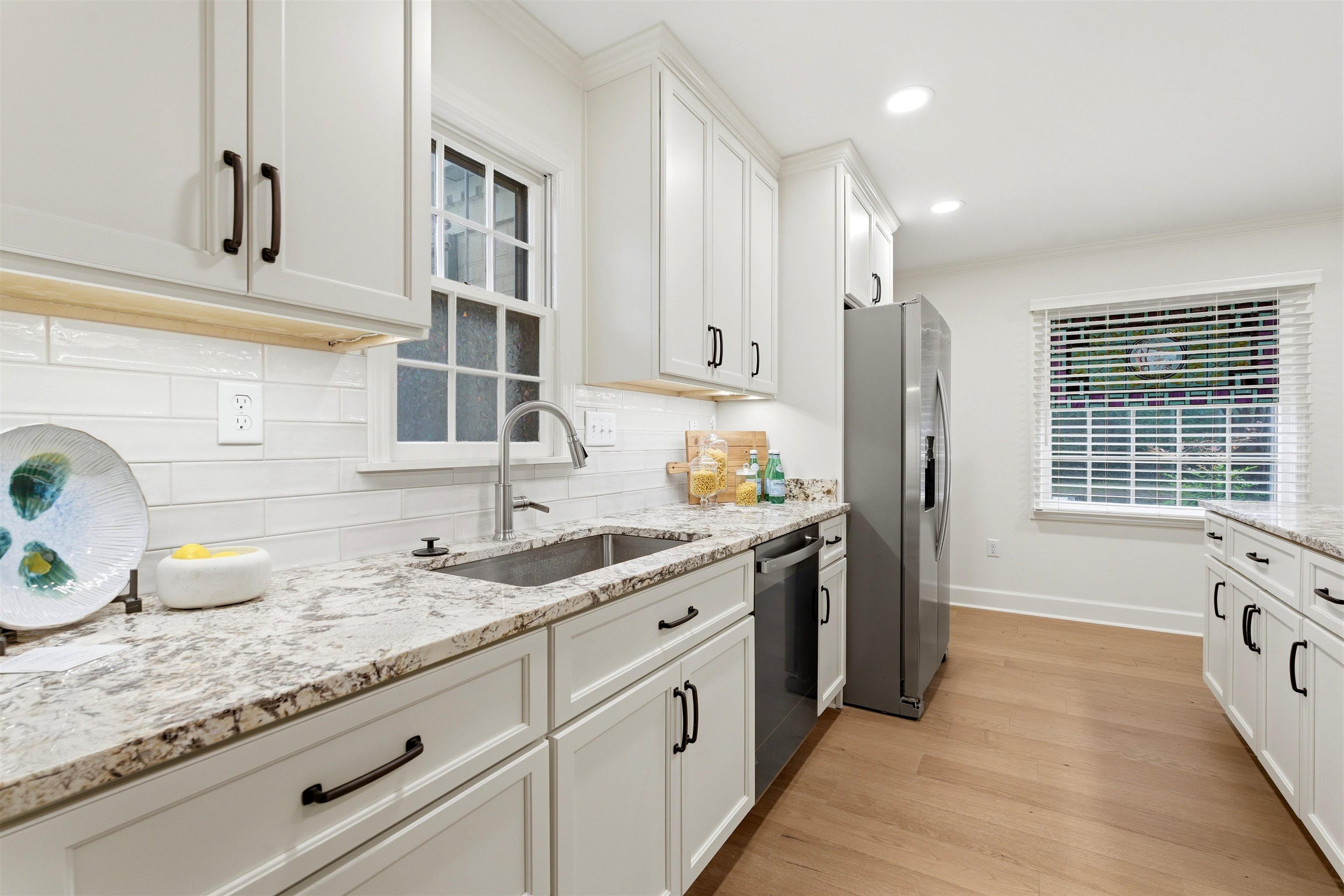 1984 Allenby Road Germantown, TN 38139 - Photo 11 of 37 Kitchen featuring white shaker cabinetry, stainless steel appliances, speckled stone countertops, and wood-finish flooring