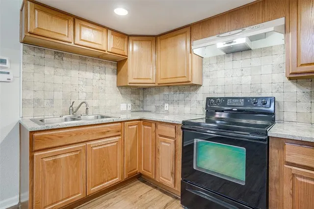 a kitchen with stainless steel appliances granite countertop a sink stove and cabinets