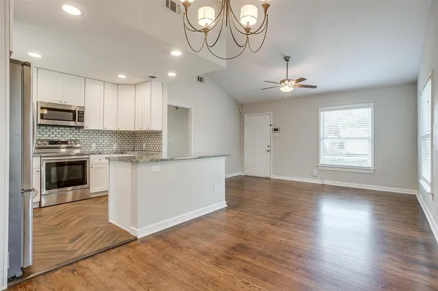 a kitchen with stainless steel appliances granite countertop a stove a sink and a microwave