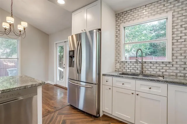 a kitchen with granite countertop a refrigerator and a sink