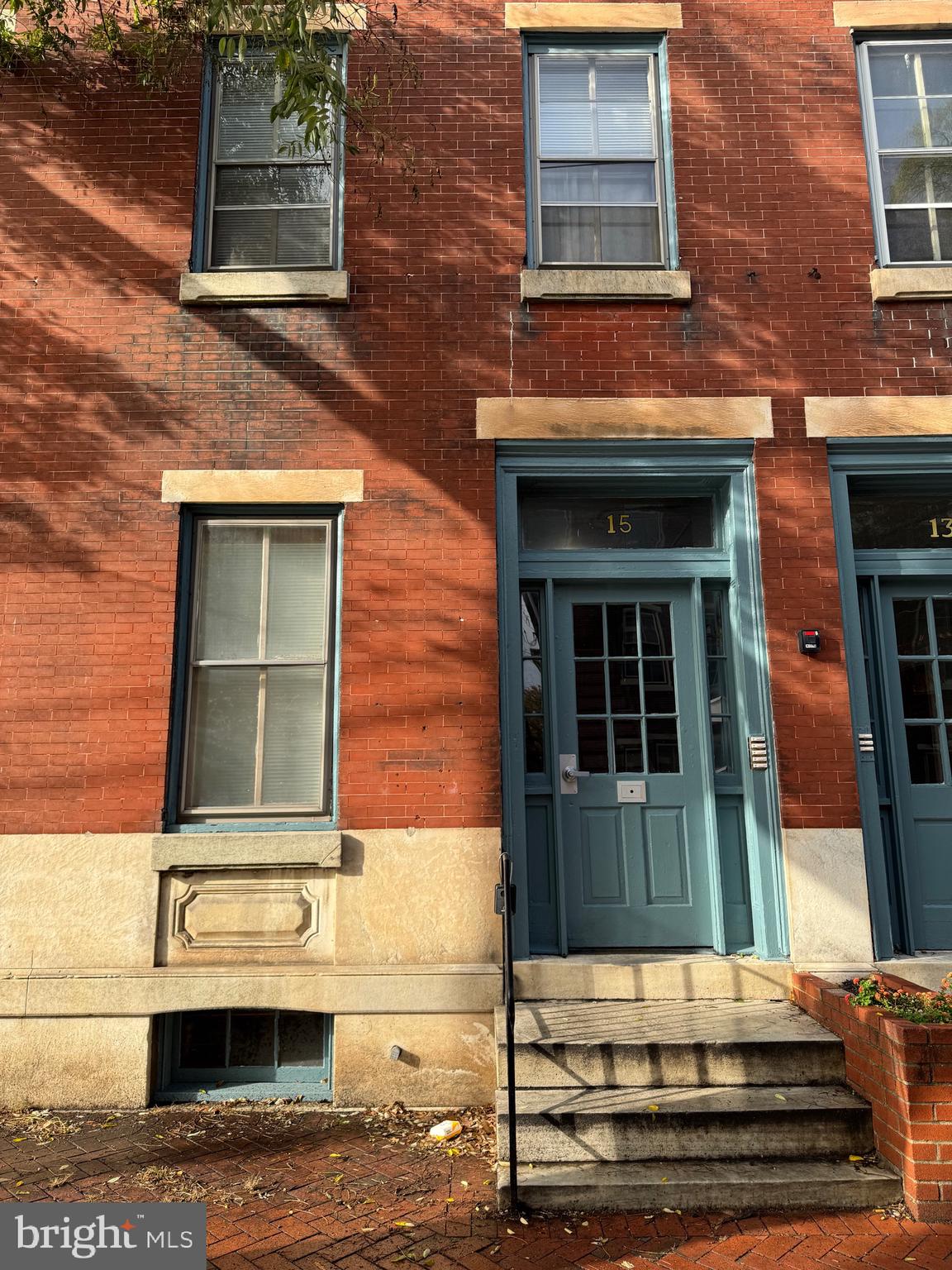 front view of a brick house with a small yard