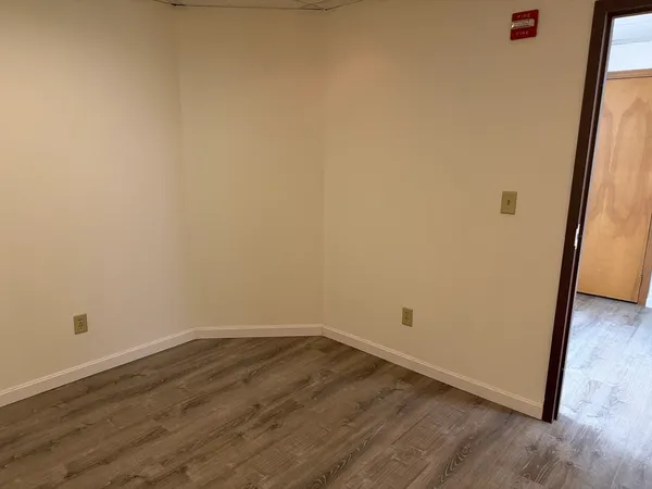 a view of a room with wooden floor and a window