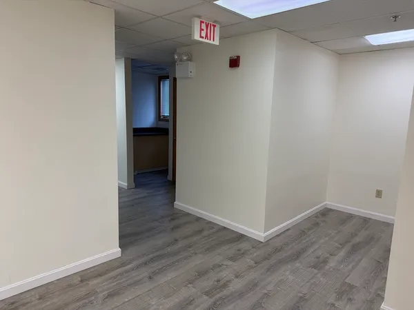 a view of an empty room with wooden floor and closet