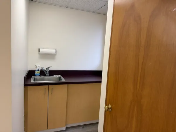 a view of a room with a sink and cabinets