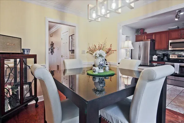 a view of a dining room with furniture a chandelier and wooden floor