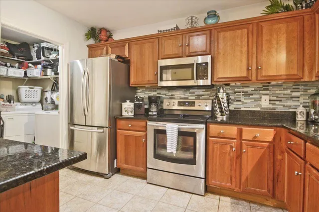 a kitchen with stainless steel appliances granite countertop a refrigerator sink and stove
