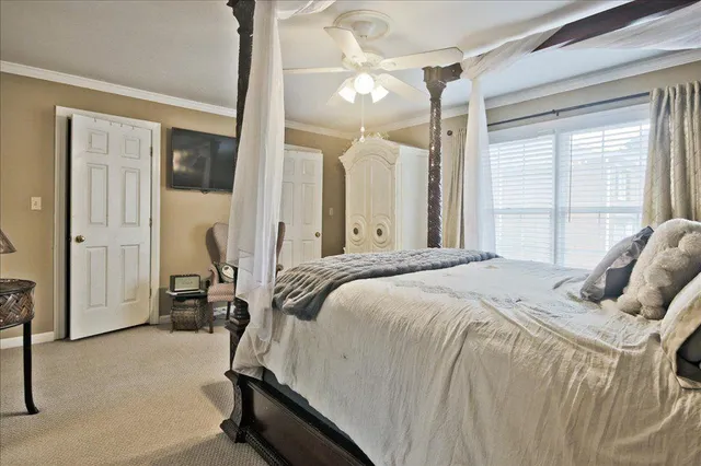 a bedroom with a large bed and a chandelier