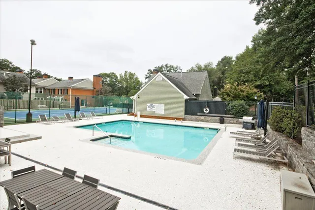 a view of a tennis ground with large trees