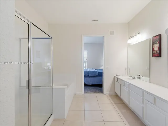 a bathroom with a double vanity sink a toilet and shower