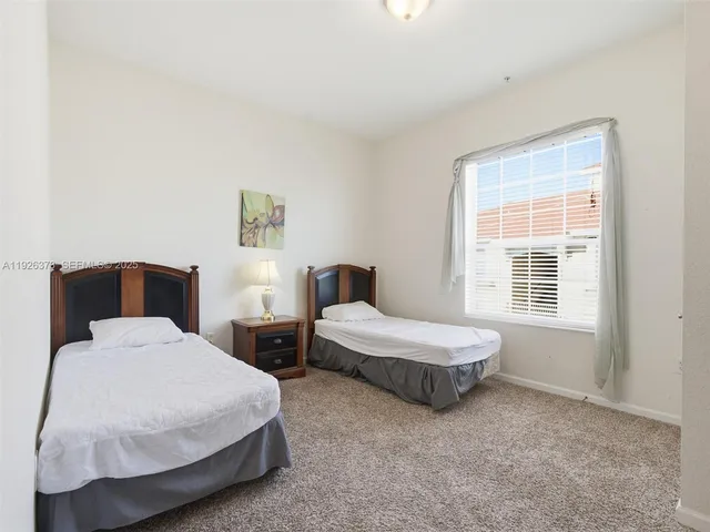 a bedroom with two beds and a window