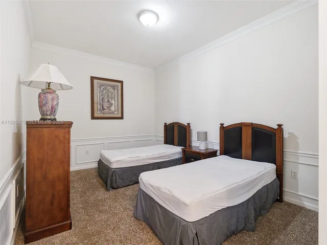 a bedroom with two beds and painting on the wall