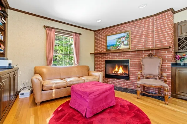 a living room with furniture a rug wooden floor and a large window