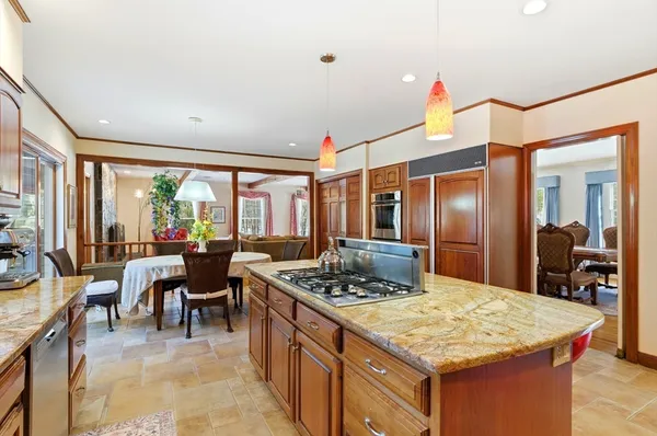 a kitchen with stainless steel appliances granite countertop a sink a stove a counter space and cabinets