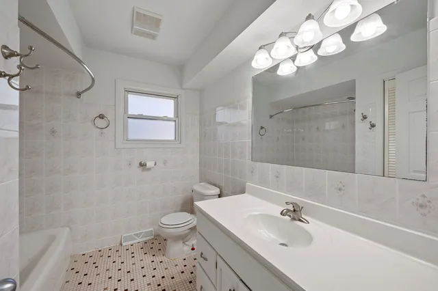 a bathroom with a sink a toilet a mirror a vanity and shower