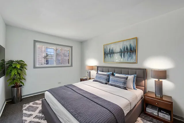 a bedroom with bed and a potted plant