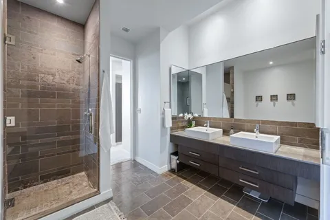 a bathroom with a double vanity sink mirror and shower