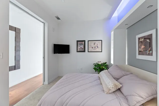 a bedroom with a bed mirror and window