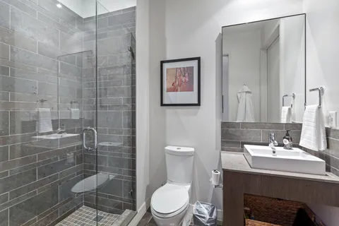 a bathroom with a sink a toilet and shower