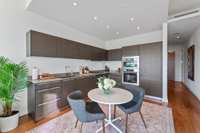 a kitchen with stainless steel appliances granite countertop a kitchen island a stove a cabinets a dining table and chairs