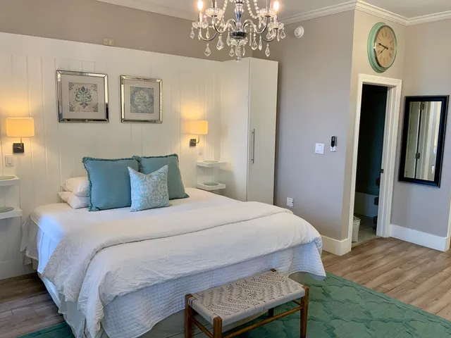 a bedroom with a bed a chandelier and a window