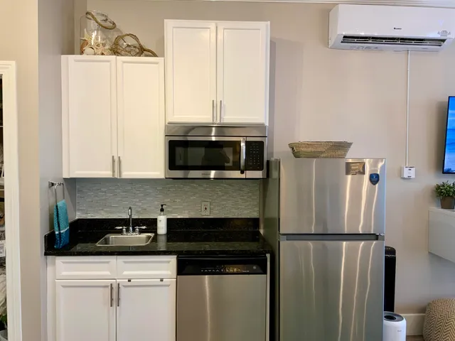 a kitchen with a sink a refrigerator and cabinets