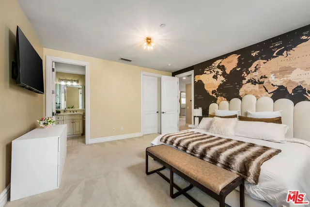 a bedroom with a bed and a flat screen tv