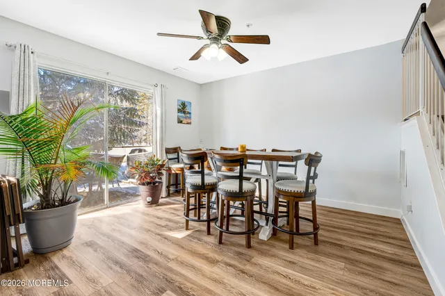 a dining room with furniture potted plants and wooden floor