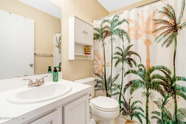 a bathroom with a sink a mirror a potted plant and a toilet