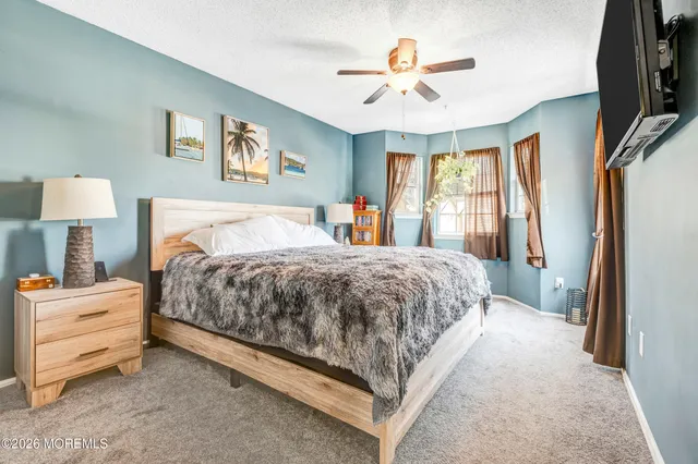 a spacious bedroom with a bed and a chandelier