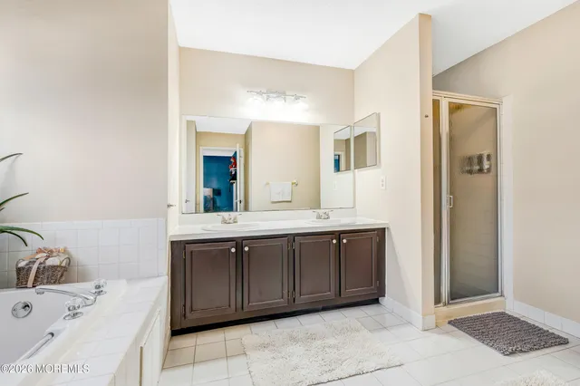 a spacious bathroom with a tub sink and mirror