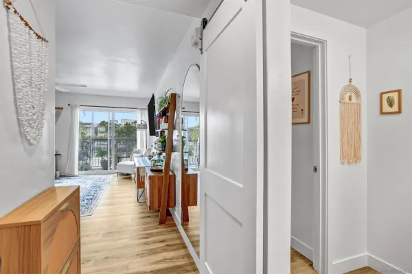 a living room with stainless steel appliances kitchen island granite countertop a couch and a flat screen tv