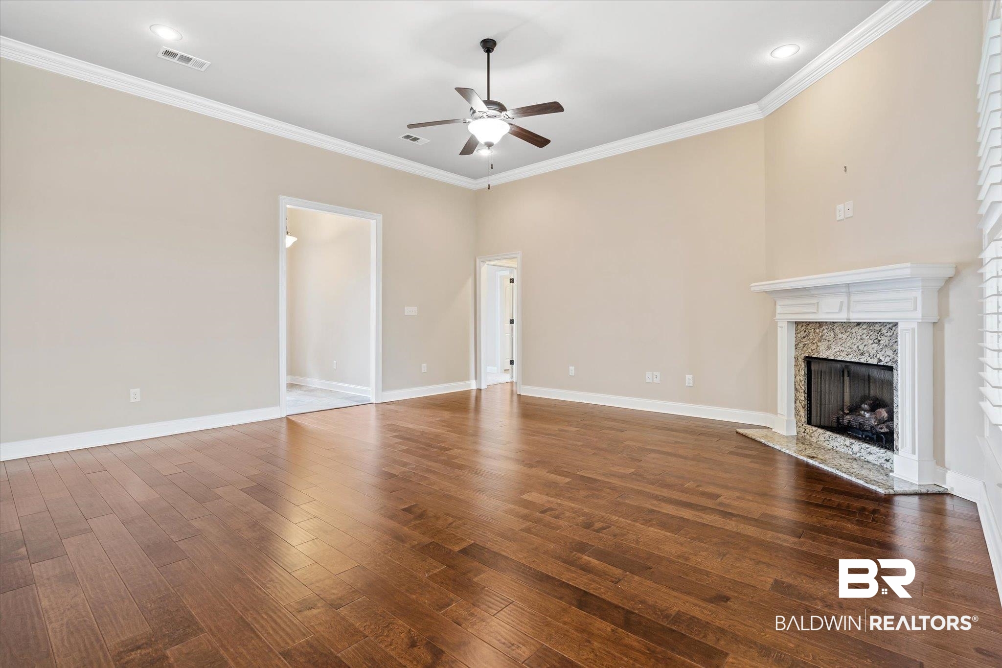 423 Breckin Drive Fairhope, AL 36532 - Photo 6 of 31 Unfurnished living room featuring crown molding, ceiling fan, a high end fireplace, and dark hardwood / wood-style floors