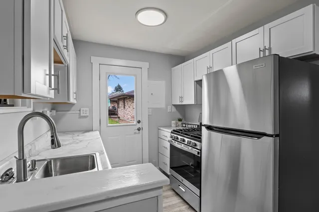 a kitchen with granite countertop a refrigerator and a sink