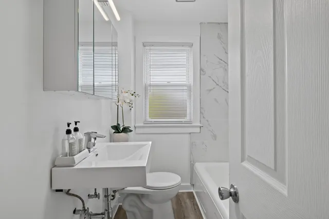 a bathroom with a sink toilet and a mirror